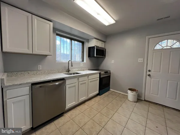 a kitchen with a sink window and cabinets