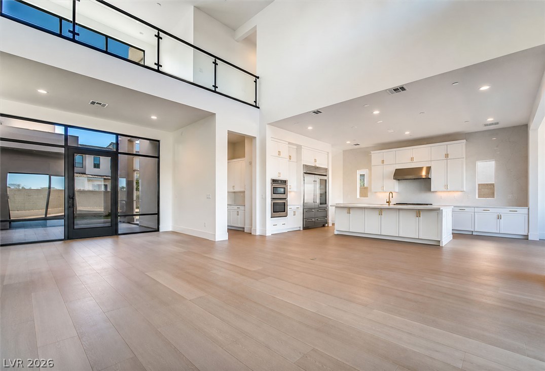4846 Shady Rdg Drive Las Vegas, NV 89135 - Photo 1 of 60 An open-concept living space with high ceilings and a modern kitchen creates a welcoming atmosphere.