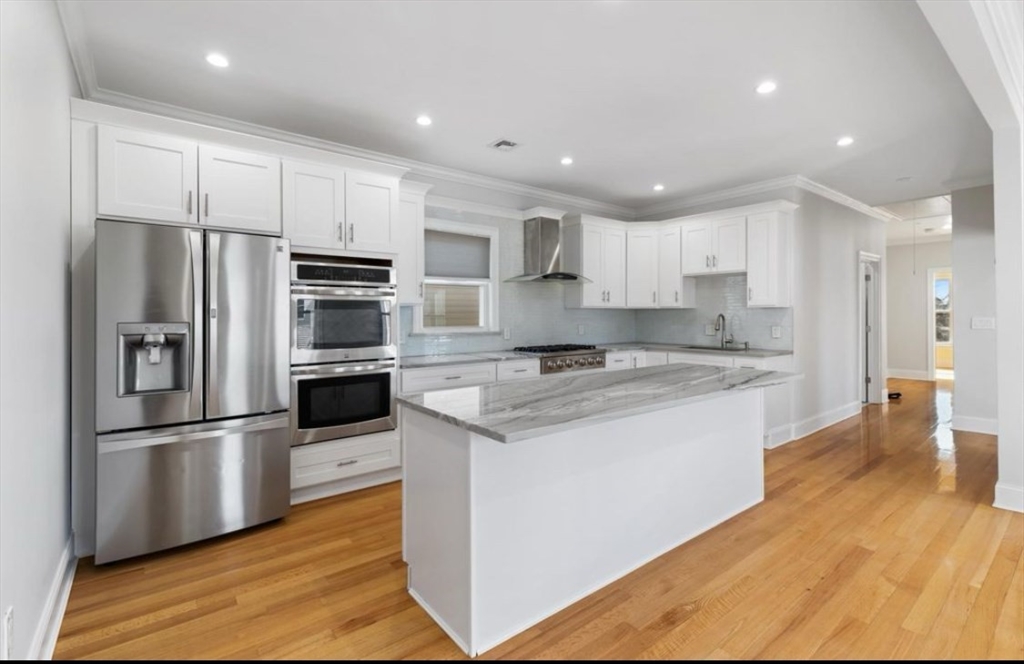 27 Lyon Street, Unit 3 Boston, MA 02122 - Photo 2 of 10 a kitchen with stainless steel appliances granite countertop a refrigerator a sink and a stove