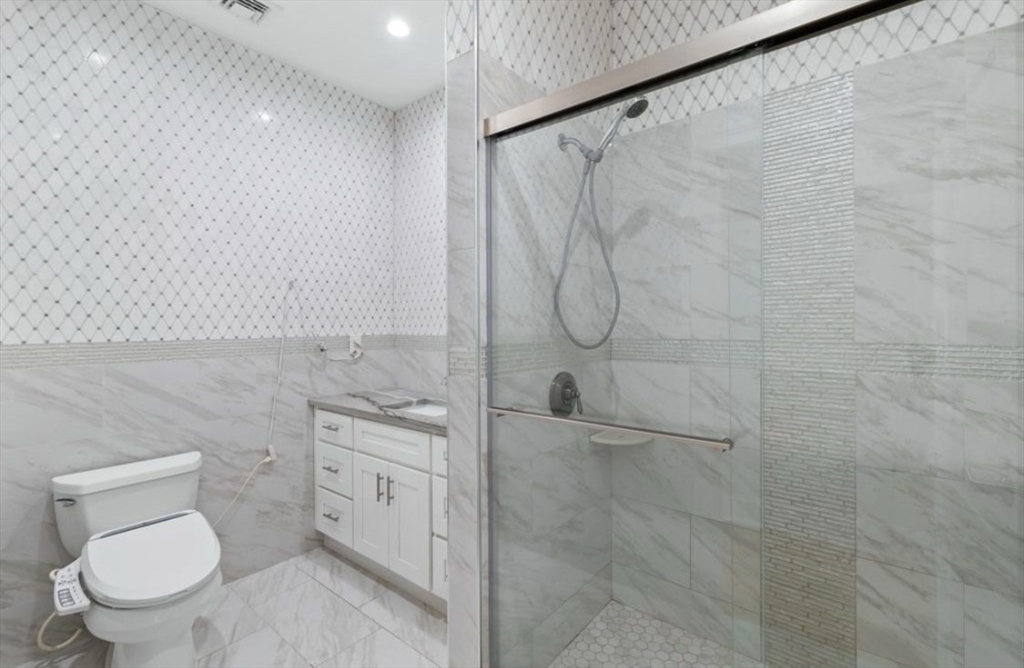 27 Lyon Street, Unit 3 Boston, MA 02122 - Photo 6 of 10 a bathroom with a granite countertop toilet a sink and shower