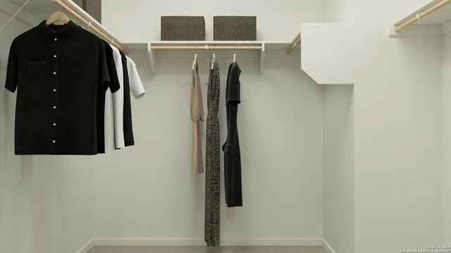 a view of walk in closet with clothes and shoes