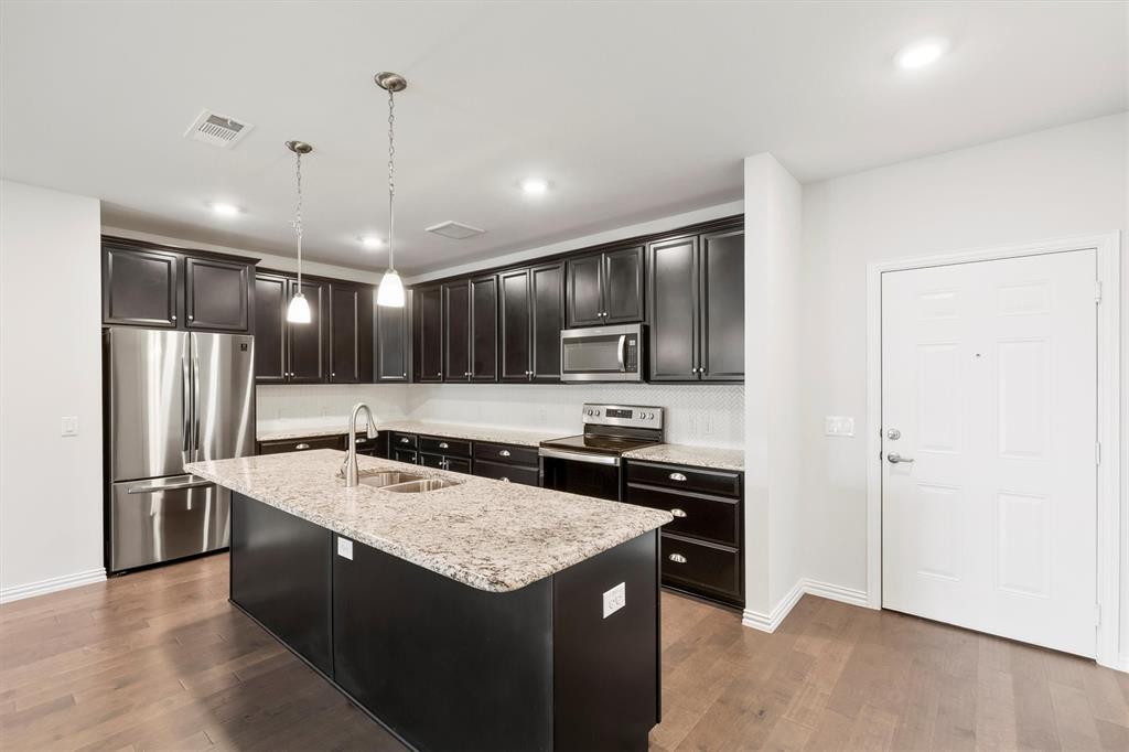 651 Watters Road, Unit 7202 Allen, TX 75013 - Photo 10 of 33 a kitchen with stainless steel appliances granite countertop a sink stove and refrigerator