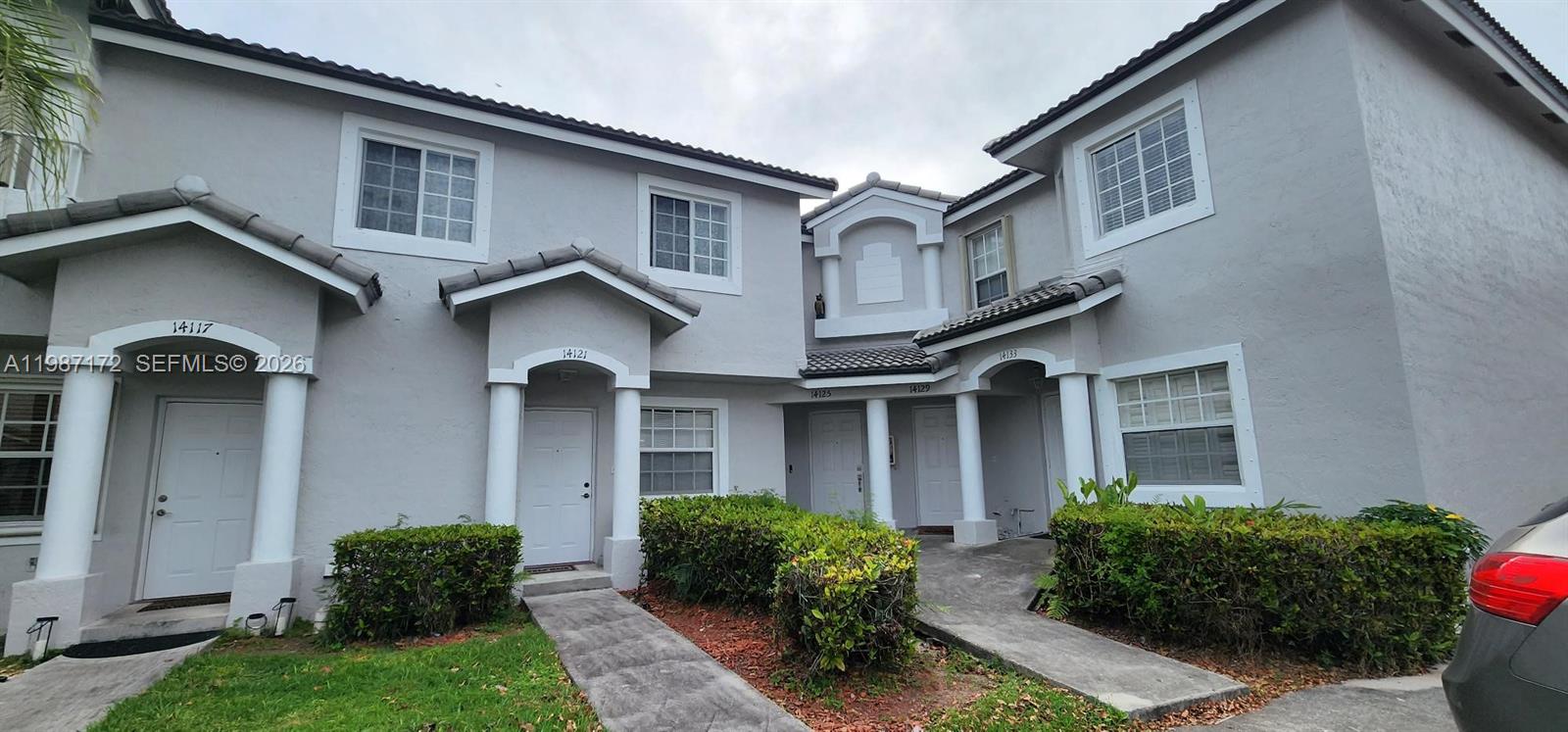 14133 Southwest 121st Place, Unit 9 Miami, FL 33186 - Photo 1 of 20 a front view of a house with garden