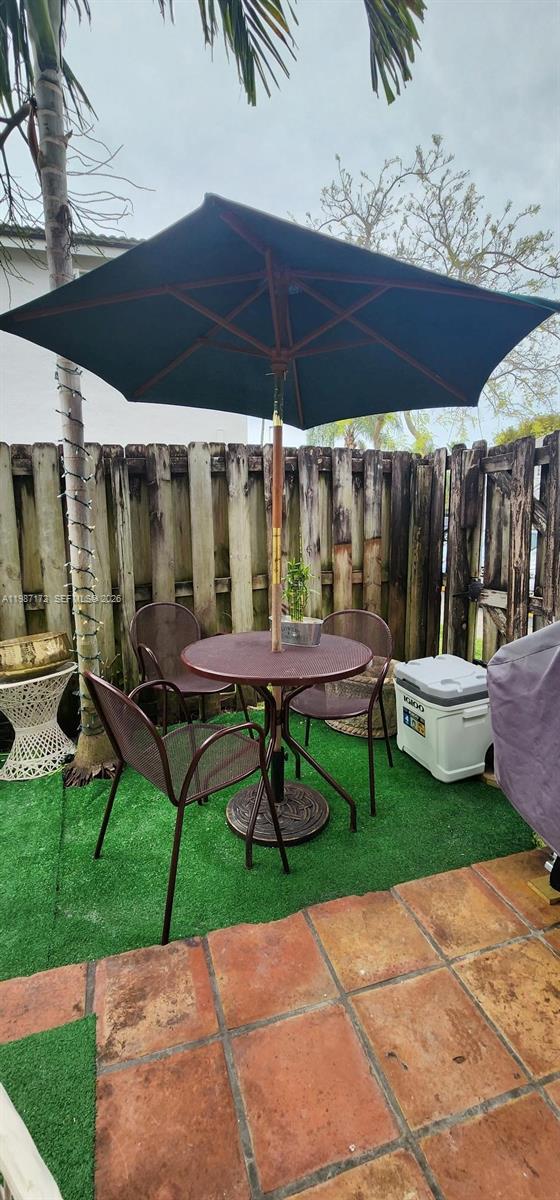 14133 Southwest 121st Place, Unit 9 Miami, FL 33186 - Photo 15 of 20 a chair and table sitting in backyard of a house