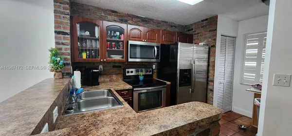 a kitchen with stainless steel appliances granite countertop a stove refrigerator and cabinets