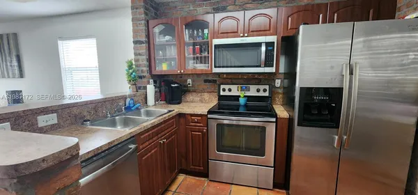 a kitchen with stainless steel appliances granite countertop a stove microwave and sink
