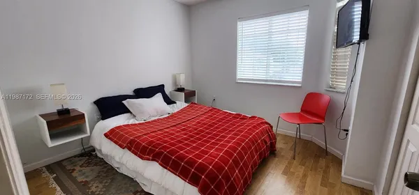 a bedroom with a bed a couch and a window