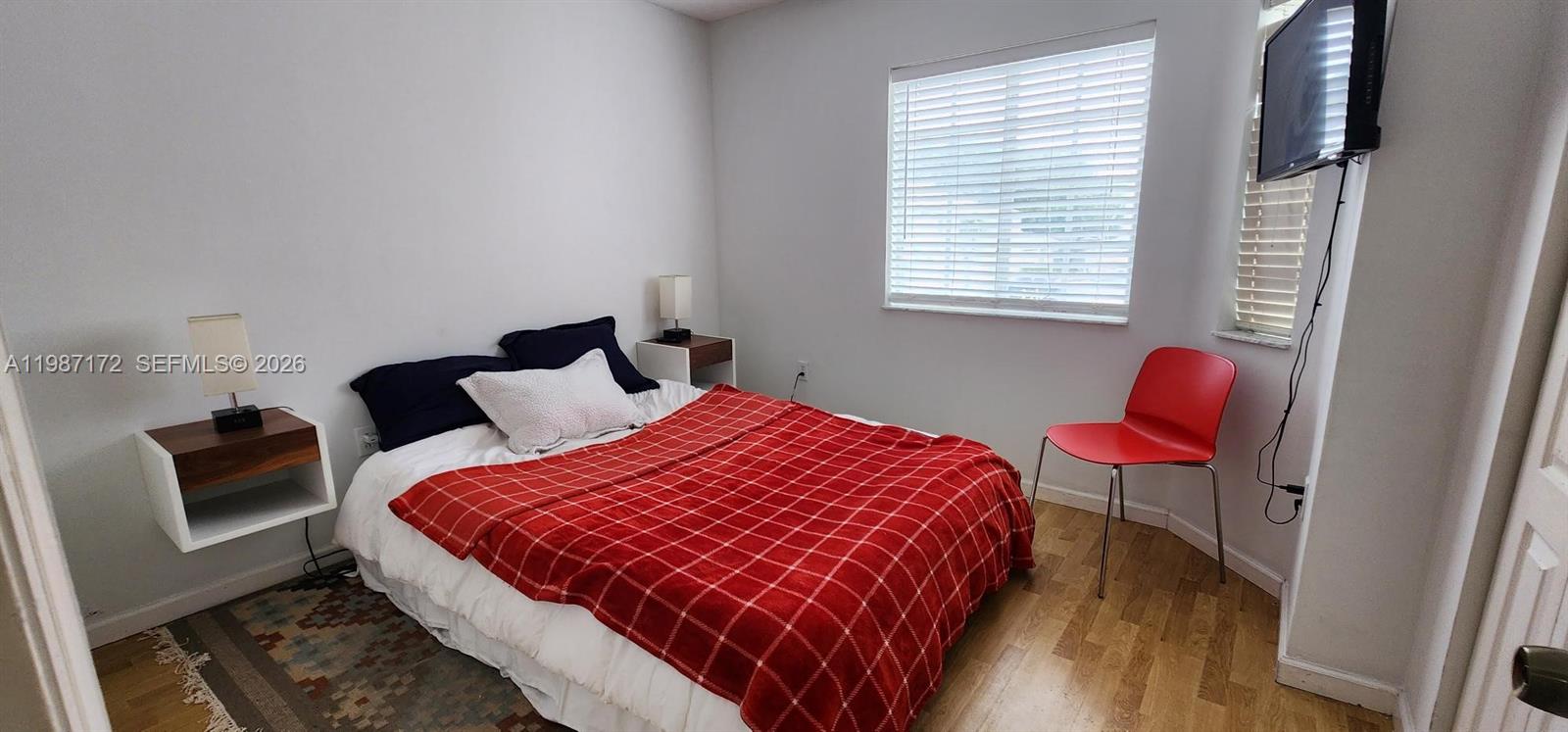 14133 Southwest 121st Place, Unit 9 Miami, FL 33186 - Photo 10 of 20 a bedroom with a bed a couch and a window