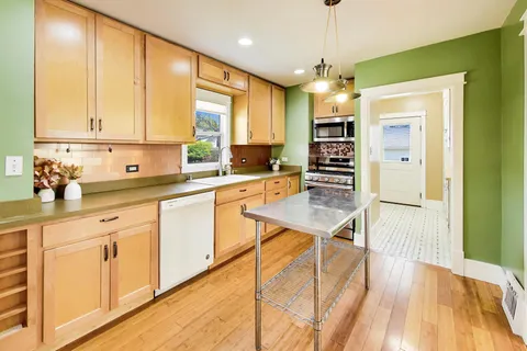 a kitchen with stainless steel appliances granite countertop a sink refrigerator and cabinets
