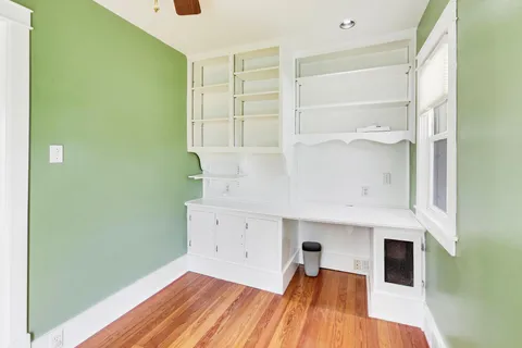 a view of empty room with wooden floor