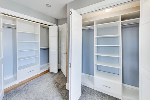 a view of walk in closet with empty racks