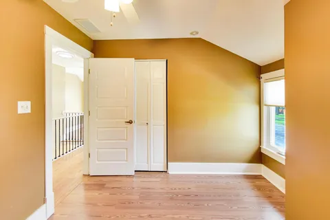 a view of a big room with wooden floor and windows