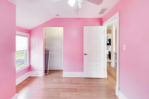 a view of a livingroom with an empty space a ceiling fan and windows