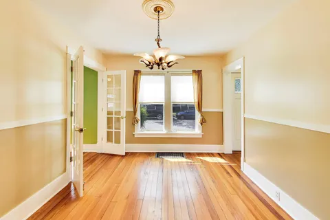 a view of an room with wooden floor and a window