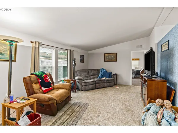 a living room with furniture a flat screen tv and a floor to ceiling window