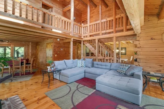 a view of a building with couches potted plants and a dining table under an umbrella