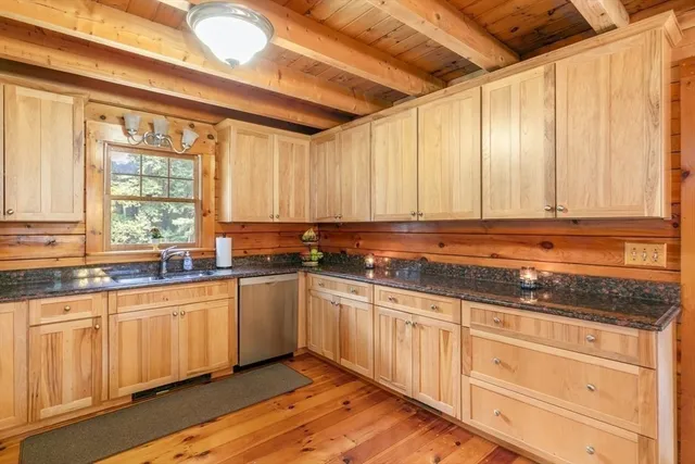 a kitchen with granite countertop white cabinets and sink