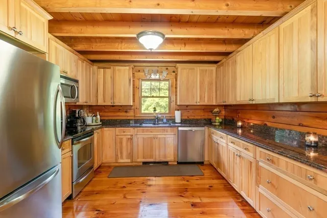 a kitchen with stainless steel appliances a stove a sink and a refrigerator