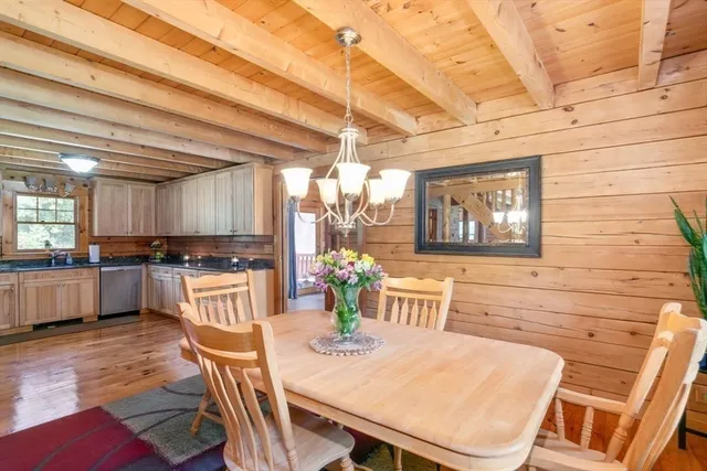a kitchen with stainless steel appliances wooden floor dining table and chairs