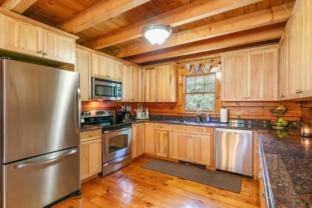 a kitchen with granite countertop stainless steel appliances a refrigerator cabinets and a sink