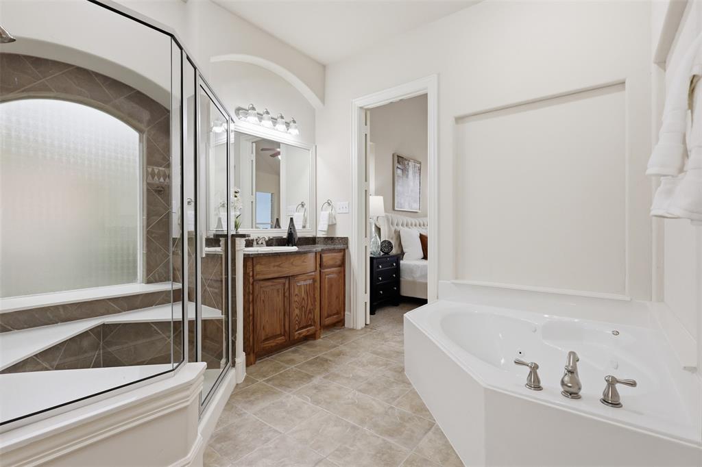 2841 Meadow Ridge Drive Prosper, TX 75078 - Photo 23 of 40 a bathroom with a tub a sink and a mirror