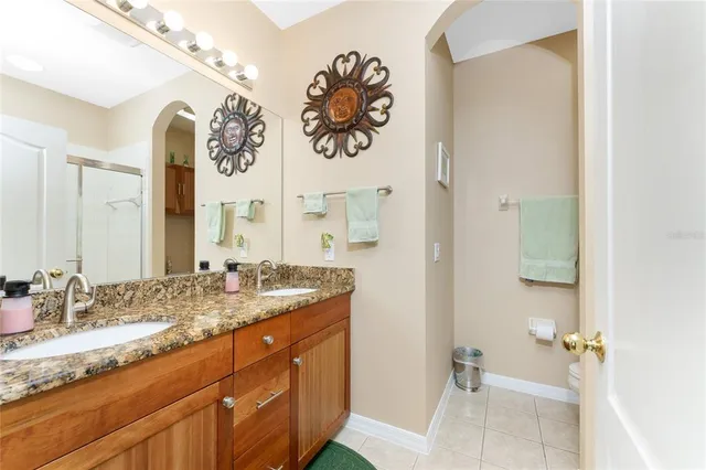 a bathroom with a granite countertop sink a toilet and a mirror