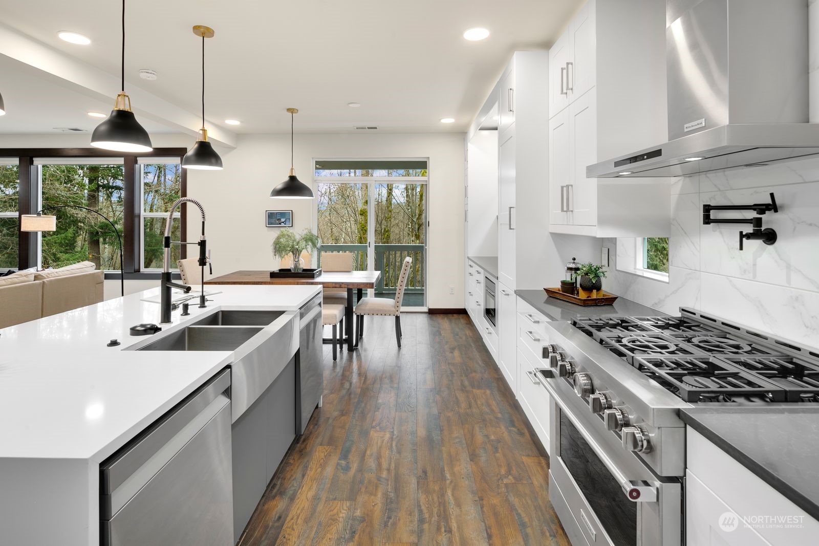17605 3rd Avenue Southeast Bothell, WA 98012 - Photo 10 of 38 a kitchen with stainless steel appliances granite countertop a stove a sink dishwasher and a dining table with wooden floor