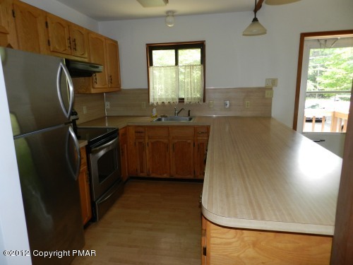 734 Decker Road Bushkill, PA 18324 - Photo 4 of 18 a kitchen with stainless steel appliances a refrigerator a sink a stove a counter top space and a window