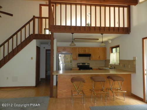 734 Decker Road Bushkill, PA 18324 - Photo 5 of 18 a kitchen with stainless steel appliances kitchen island granite countertop a refrigerator a stove and a sink with wooden floor