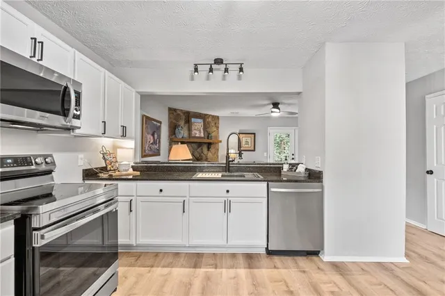 a kitchen with granite countertop a refrigerator and a stove top oven