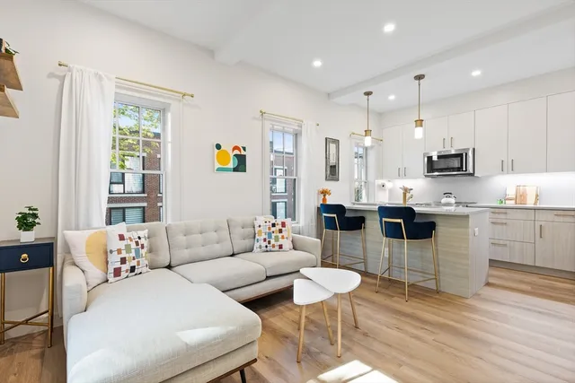 a living room with furniture and kitchen view