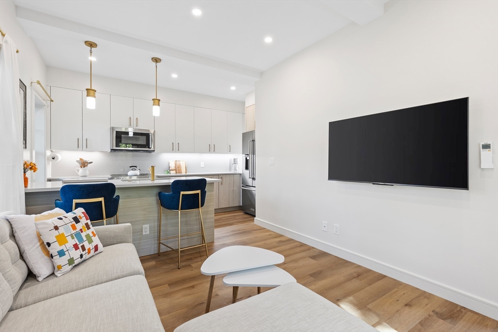 46 Lancaster Terrace, Unit 46 Brookline, MA 02446 - Photo 11 of 25 a living room with stainless steel appliances kitchen island furniture and a flat screen tv