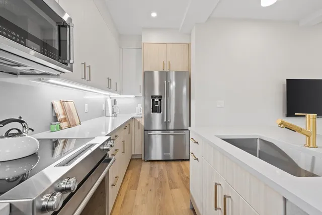 a kitchen with a refrigerator sink and wooden floor