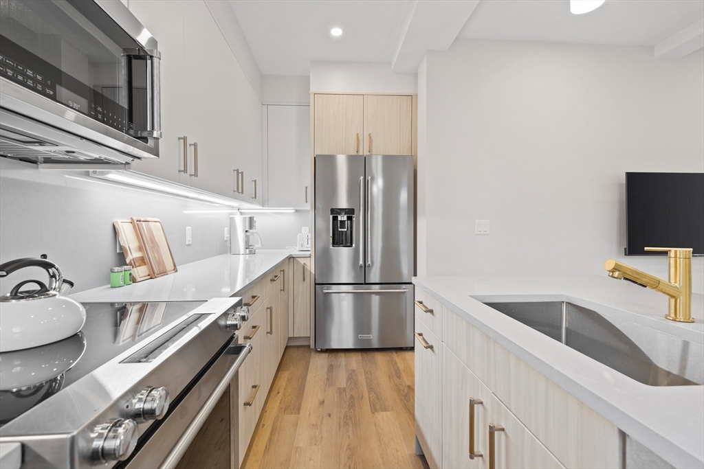 46 Lancaster Terrace, Unit 46 Brookline, MA 02446 - Photo 7 of 25 a kitchen with a refrigerator sink and wooden floor