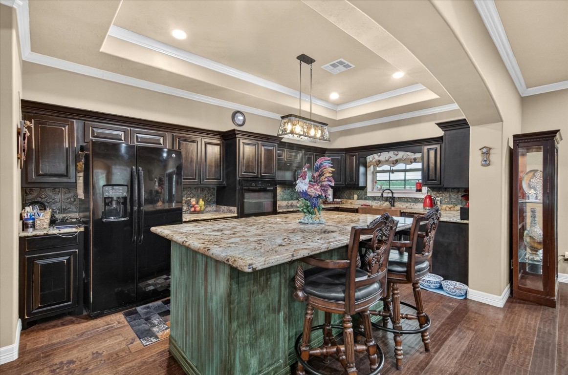 1755 McBride-Devillier Loop Winnie, TX 77665 - Photo 14 of 44 a kitchen with stainless steel appliances kitchen island granite countertop a table chairs and a refrigerator