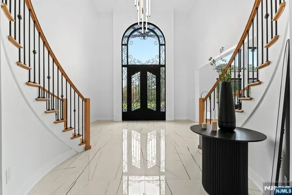 a view of staircase with railing and a chandelier