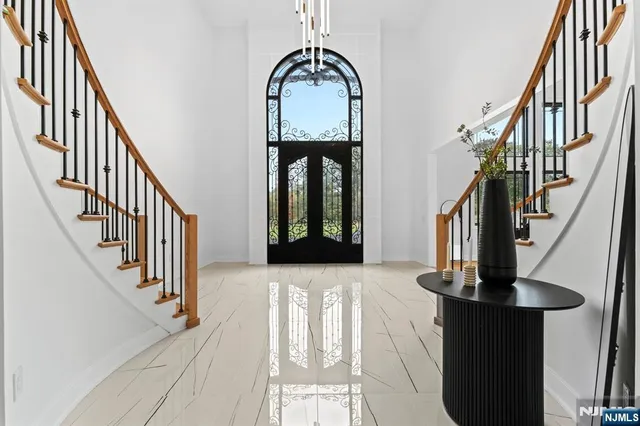a view of staircase with railing and a chandelier