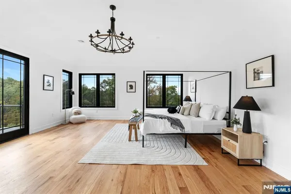 a living room with furniture large window and wooden floor