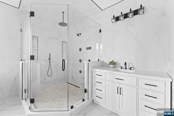 a bathroom with a shower sink and mirror