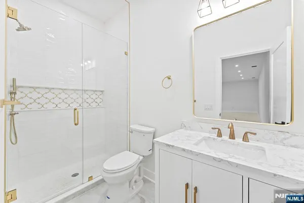 a bathroom with a granite countertop toilet a sink and a mirror