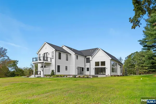 a view of a big house with a big yard and large trees