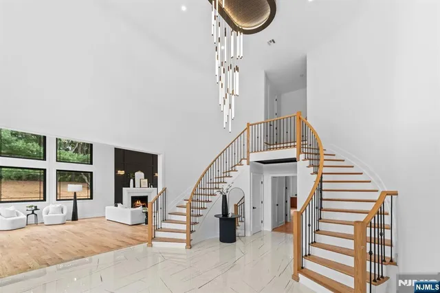 a view of staircase with railing and a chandelier
