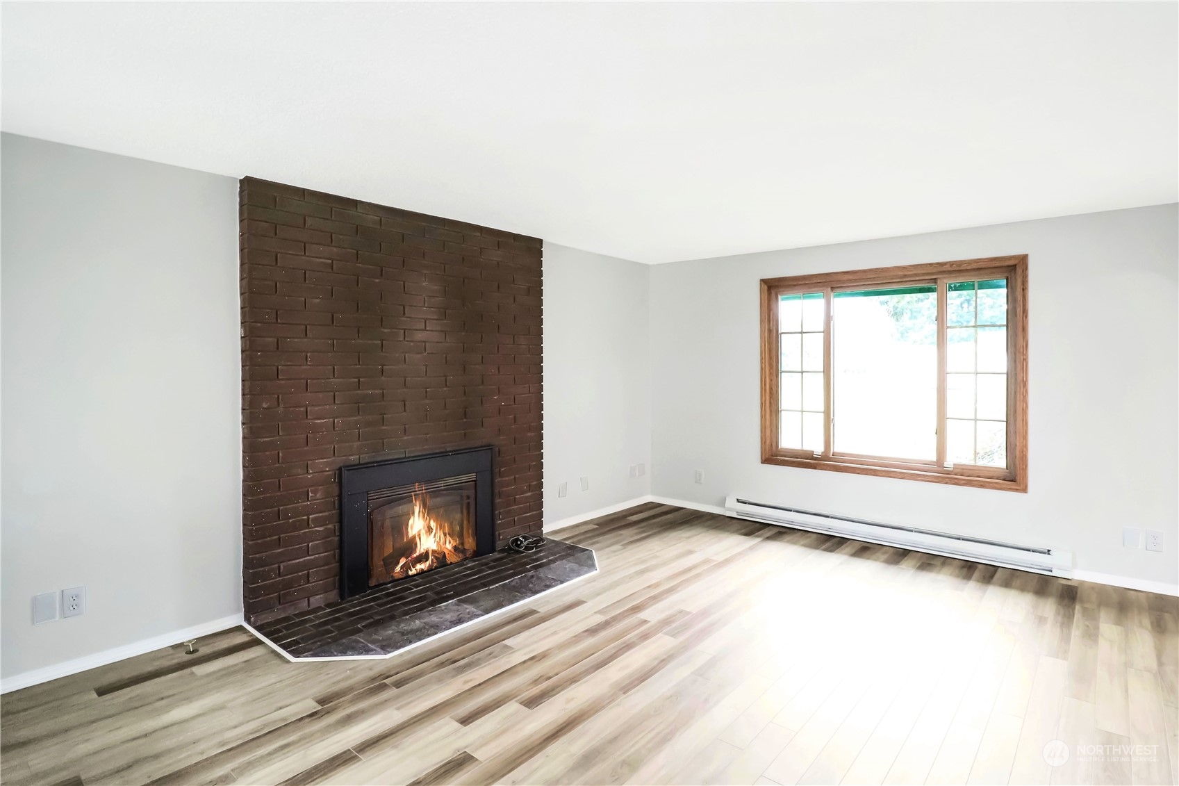 18237 Nutmeg Court Southwest Rochester, WA 98579 - Photo 19 of 34 a view of an empty room with wooden floor fireplace and a window