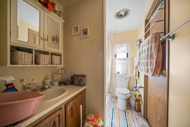 a bathroom with a sink vanity mirror and toilet