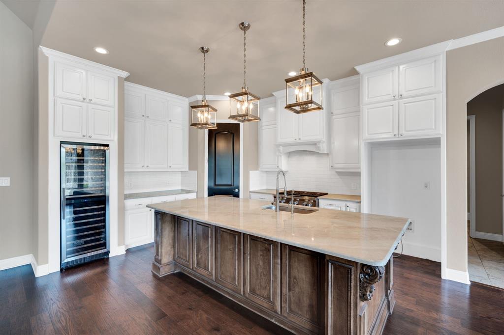 136 Sullivan Way Waxahachie, TX 75167 - Photo 12 of 40 a kitchen with kitchen island a wooden floor and white appliances