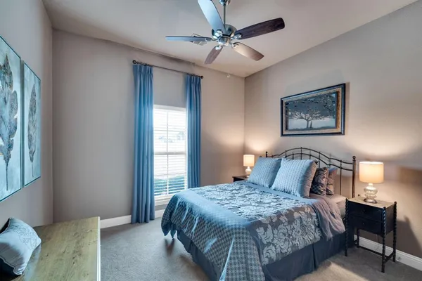 a bedroom with a large bed and a chandelier