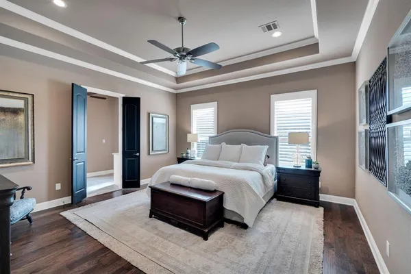 a bedroom with a large bed and a chandelier