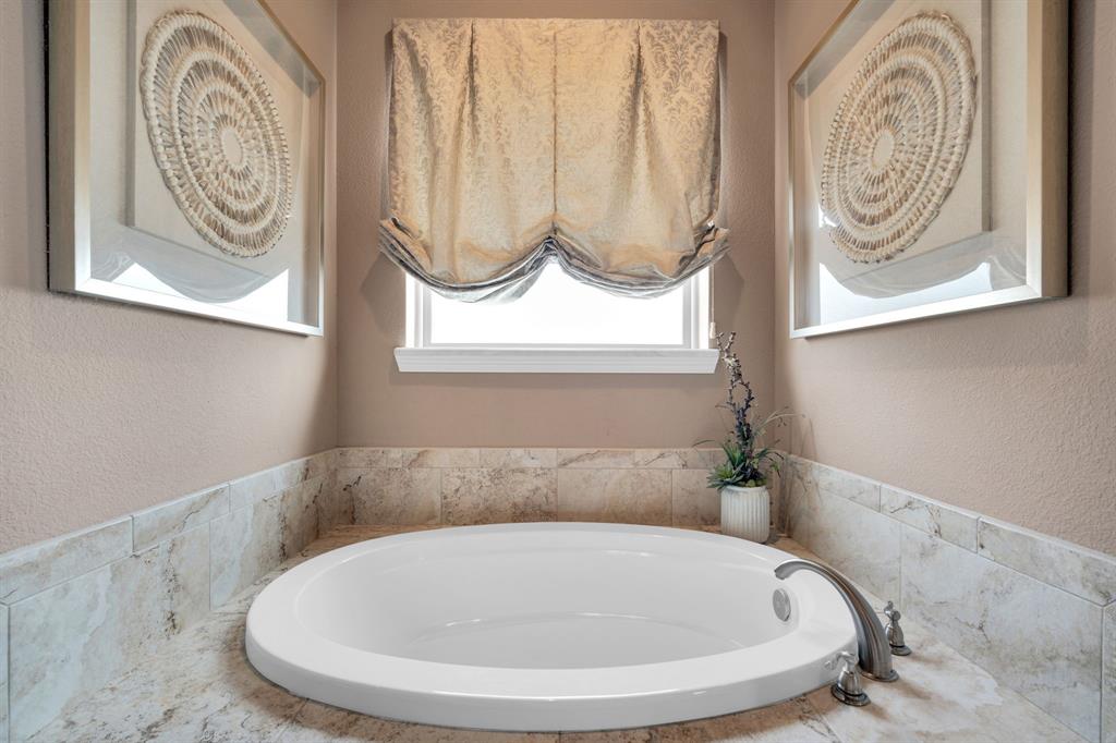 136 Sullivan Way Waxahachie, TX 75167 - Photo 24 of 40 a bathroom with a bathtub and a window