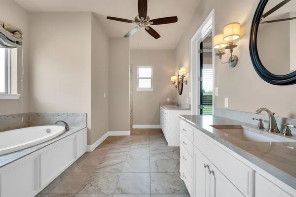 a spacious bathroom with a sink a mirror a bathtub and a shower