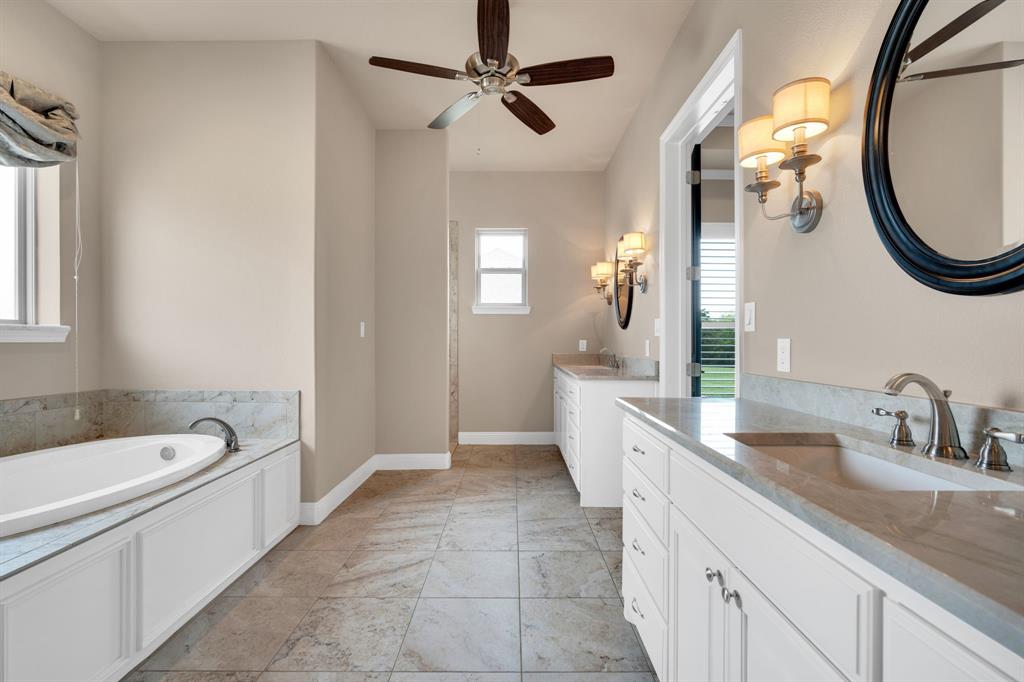 136 Sullivan Way Waxahachie, TX 75167 - Photo 25 of 40 a spacious bathroom with a sink a mirror a bathtub and a shower